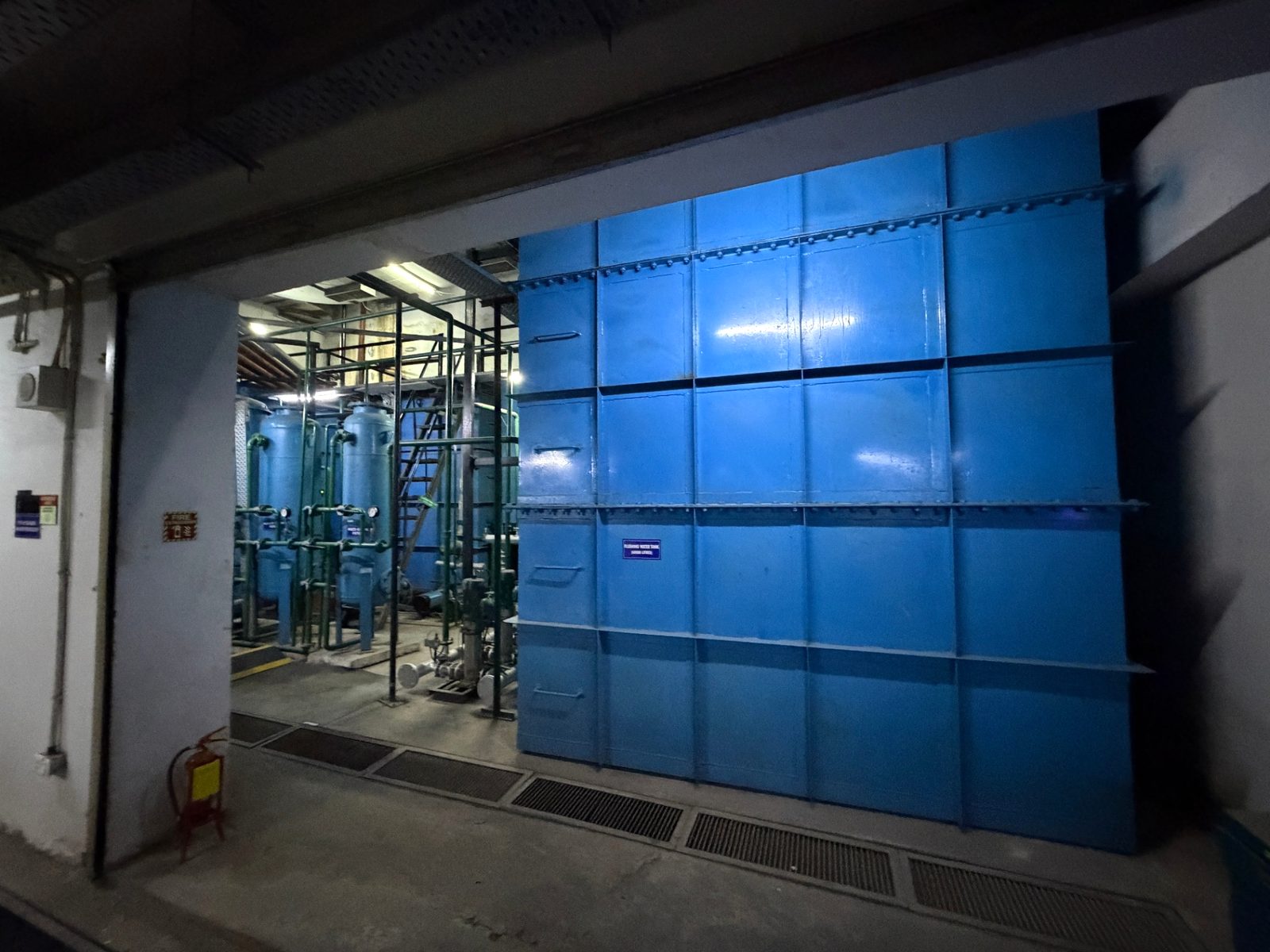 Large fabricated blue panel tank at the entrance to the treatment plant area